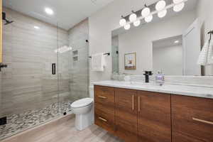 Bathroom featuring vanity, a stall shower, and recessed lighting