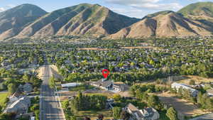 Aerial view of property and surrounding area featuring nearby suburban area and mountains