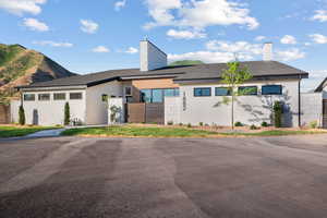 View of front of home with a chimney, stucco siding, and a mountain view
