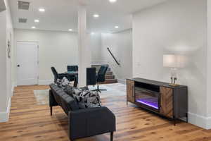 Living area with stairway, light wood-style flooring, and recessed lighting