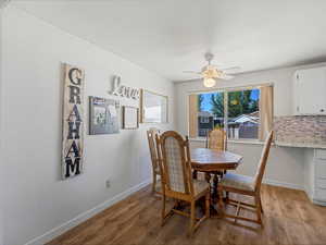 Dining area with ceiling fan and large window