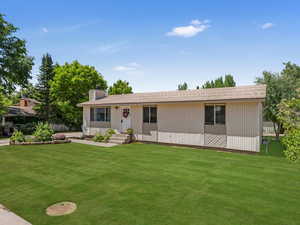 View of front of property with a chimney and a front lawn