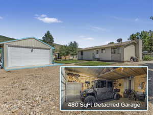 View of front of house with an outbuilding and a garage