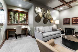 Carpeted living area with a desk, coffered ceiling, beamed ceiling, and recessed lighting