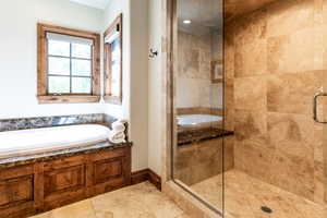 Bathroom featuring a stall shower, a garden tub, and tile patterned flooring