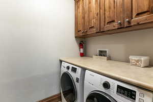Laundry area with cabinet space and washing machine and clothes dryer