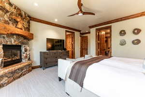Carpeted bedroom with ornamental molding, a fireplace, recessed lighting, and ceiling fan