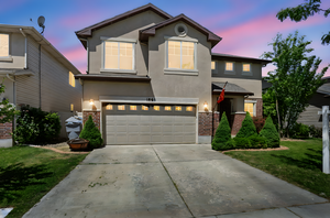 Traditional-style house featuring brick siding, stucco siding, an attached garage, concrete driveway, and a yard