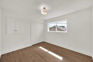 Unfurnished bedroom featuring wood finished floors and a closet