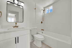 Full bathroom featuring vanity, bathing tub / shower combination, and a textured ceiling