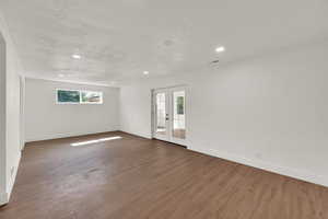Spare room featuring a textured ceiling, dark wood finished floors, and recessed lighting