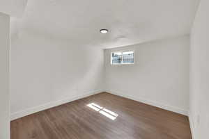 Spare room featuring a textured ceiling and wood finished floors