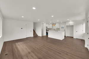Unfurnished living room featuring stairway, recessed lighting, and wood finished floors