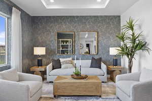 Living area featuring a raised ceiling and recessed lighting