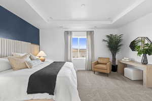 Bedroom featuring a tray ceiling and carpet flooring