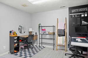 Home office with baseboards and a textured ceiling