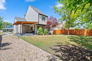 Rear view of house with a shingled roof and a patio