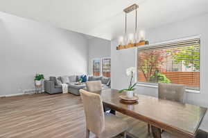 Dining room featuring light wood-type flooring and vaulted ceiling
