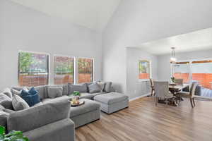 Living area with high vaulted ceiling and light wood-style floors