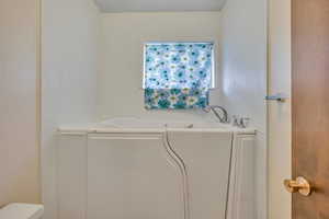 Bathroom with a garden tub and toilet