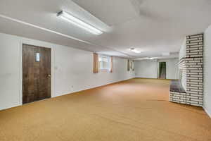 Below grade area featuring carpet, a textured ceiling, and a fireplace,walk-out