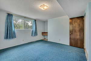 Unfurnished bedroom with carpet flooring and a textured ceiling
