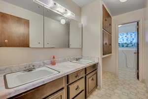 Bathroom with double vanity and tile patterned floors