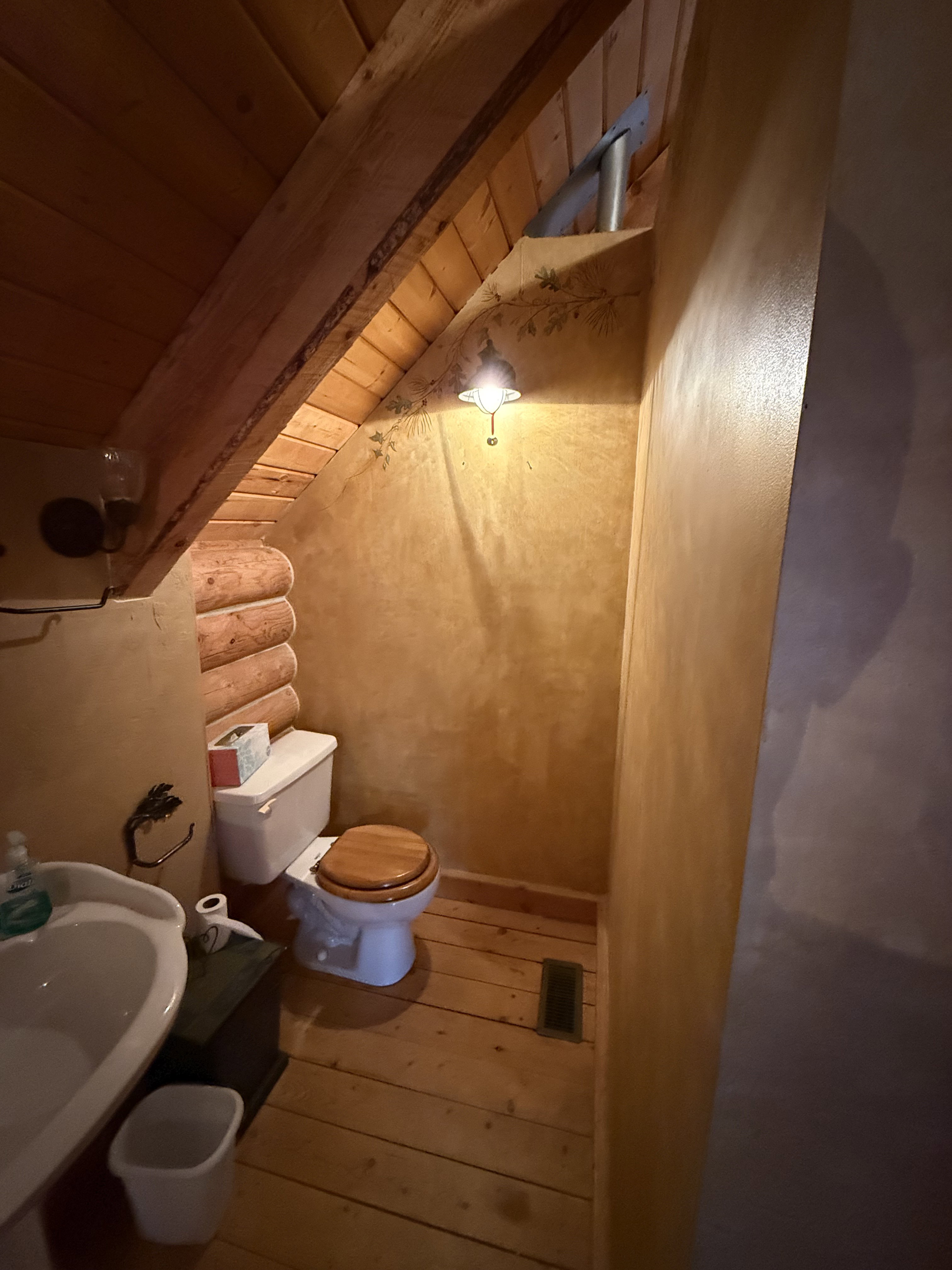 Bathroom with rustic walls, hardwood / wood-style flooring, and a wood ceiling with exposed beams