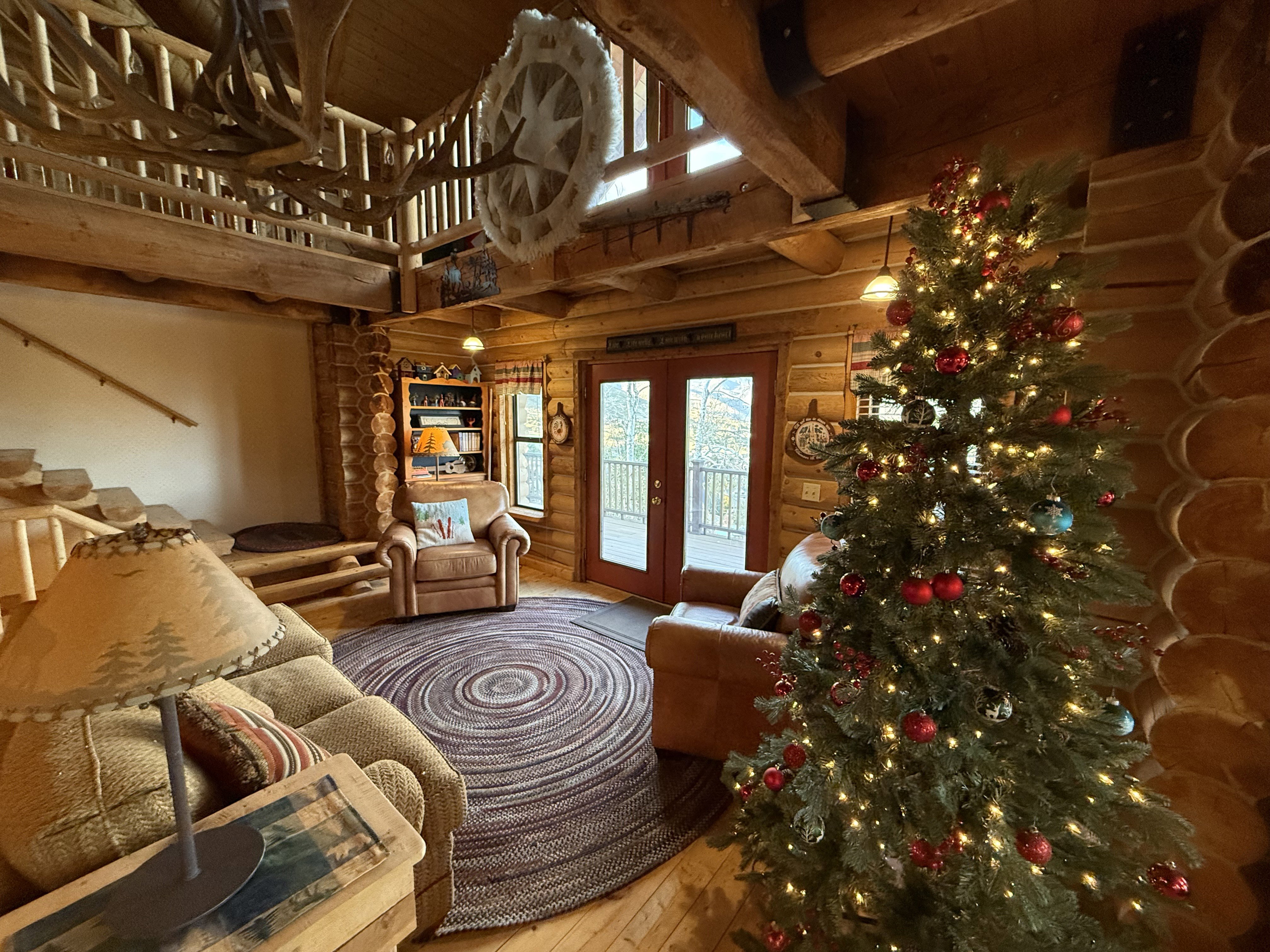 Living area with hardwood / wood-style flooring, a high ceiling, french doors, beam ceiling, and rustic walls