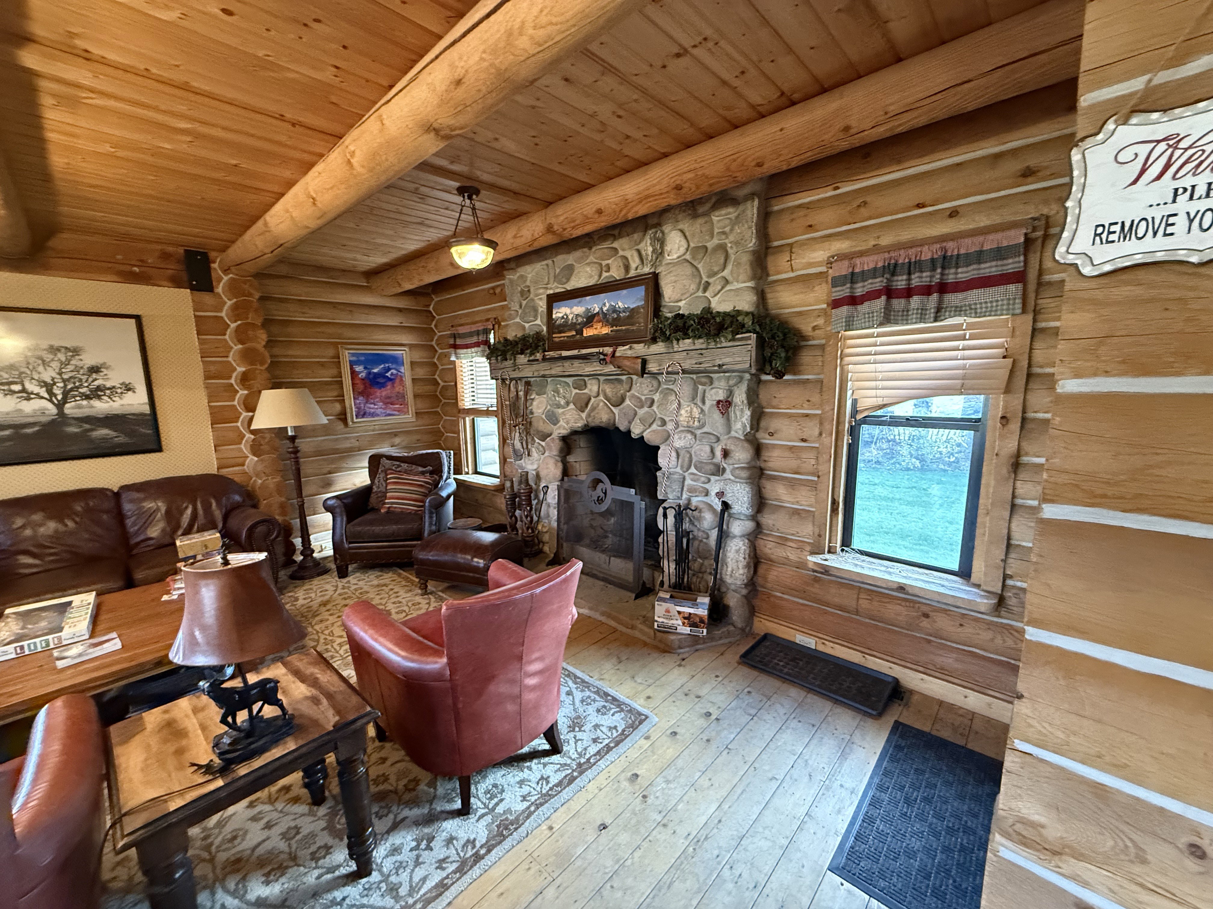 Living area featuring rustic walls, a wooden ceiling with exposed beams, hardwood / wood-style flooring, and a fireplace