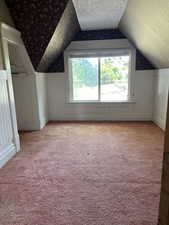 Bedroom #2, plenty of natural light, a wainscoted wall, lofted ceiling, and wallpapered walls