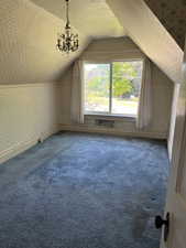 Bedroom #1,carpet floors, wallpapered walls, cozy vaulted ceiling, and chandelier.