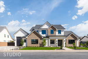 View of front of property featuring brick siding, a metal roof, concrete driveway, and stucco siding