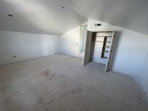 Additional living space featuring lofted ceiling and baseboards