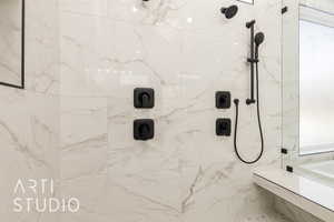 Full bath featuring a marble finish shower