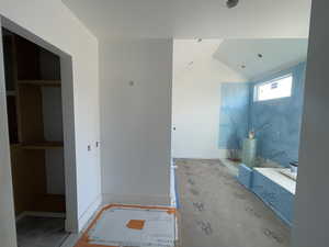 Bathroom featuring lofted ceiling and baseboards