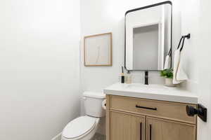 Half bathroom with vanity and toilet