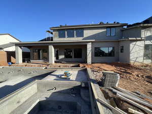 Rear view of property featuring stucco siding and a patio area