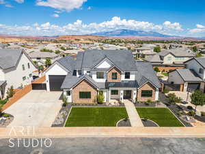 Modern farmhouse featuring driveway, a residential view, a mountain view, an attached garage, and brick siding