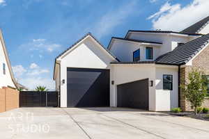 View of front of house featuring stucco siding, driveway, and a garage
