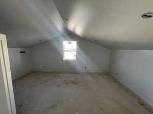 Bonus room with lofted ceiling and baseboards