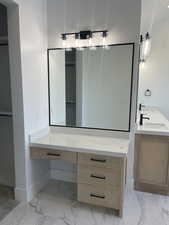 Full bath with double vanity and light marble finish floors