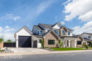 View of front of house featuring stucco siding, driveway, a porch, stone siding, and a garage