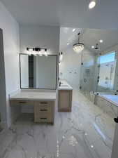 Bathroom featuring a marble finish shower, a bath, vanity, vaulted ceiling, and a chandelier