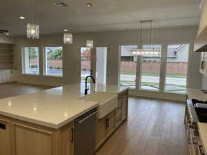 Kitchen featuring light wood-style floors, a chandelier, hanging light fixtures, appliances with stainless steel finishes, and recessed lighting
