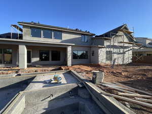 Rear view of house featuring stucco siding and a patio area