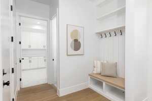 Mudroom with light wood-style flooring and baseboards