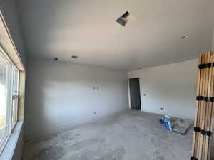 Unfurnished room featuring unfinished concrete flooring and baseboards