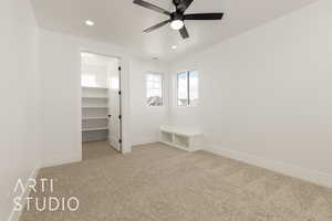 Unfurnished bedroom featuring a spacious closet, light colored carpet, recessed lighting, and a ceiling fan