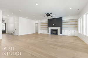 Unfurnished living room featuring a high end fireplace, recessed lighting, light wood finished floors, stairway, and ceiling fan